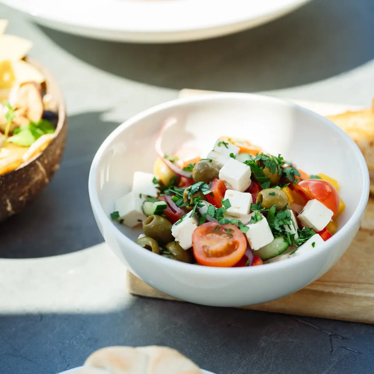 Eine Schüssel Salat mit Tomaten und Oliven.