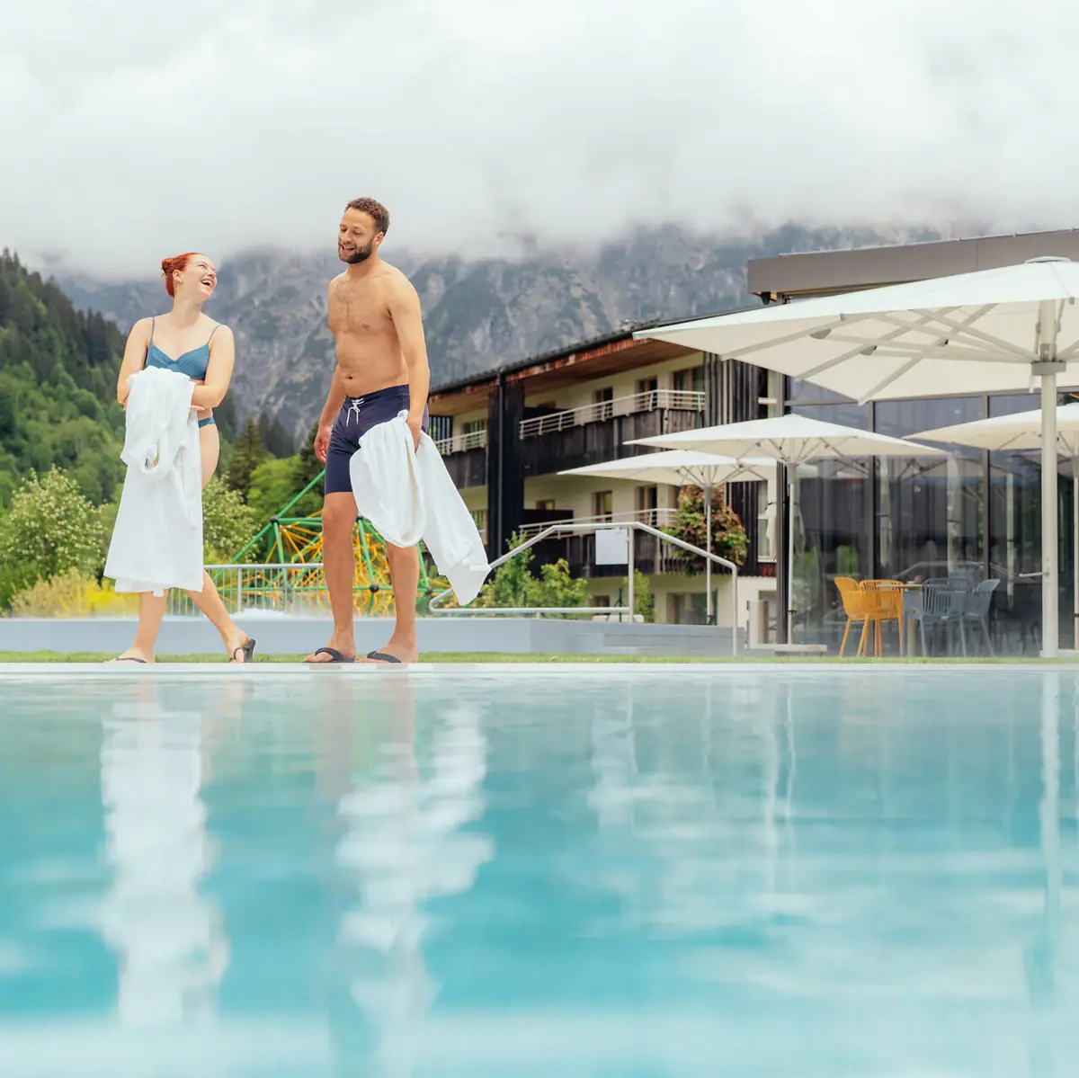 Ein Mann und eine Frau stehen neben einem Pool.