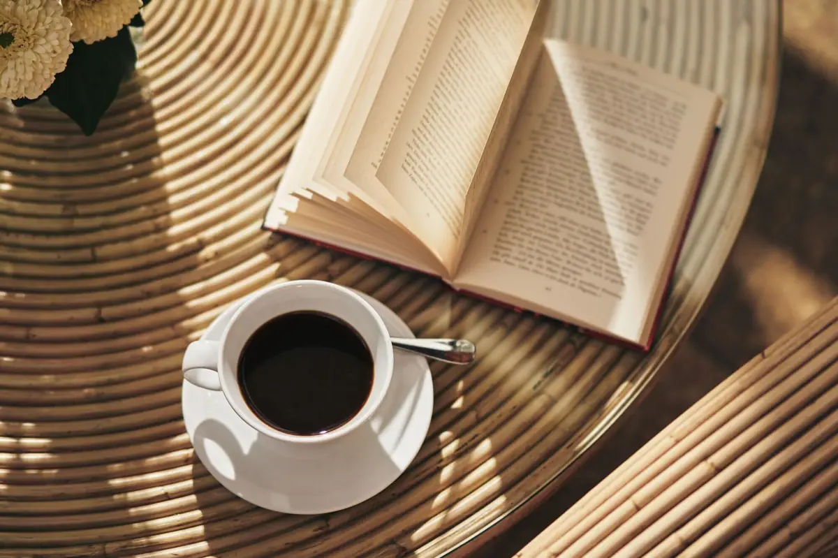 Eine Tasse Kaffee und ein Buch auf einem Tisch.