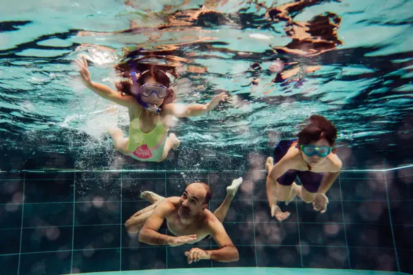 Eine Gruppe von Menschen schwimmt unter Wasser im Badehaus Werfenweng.