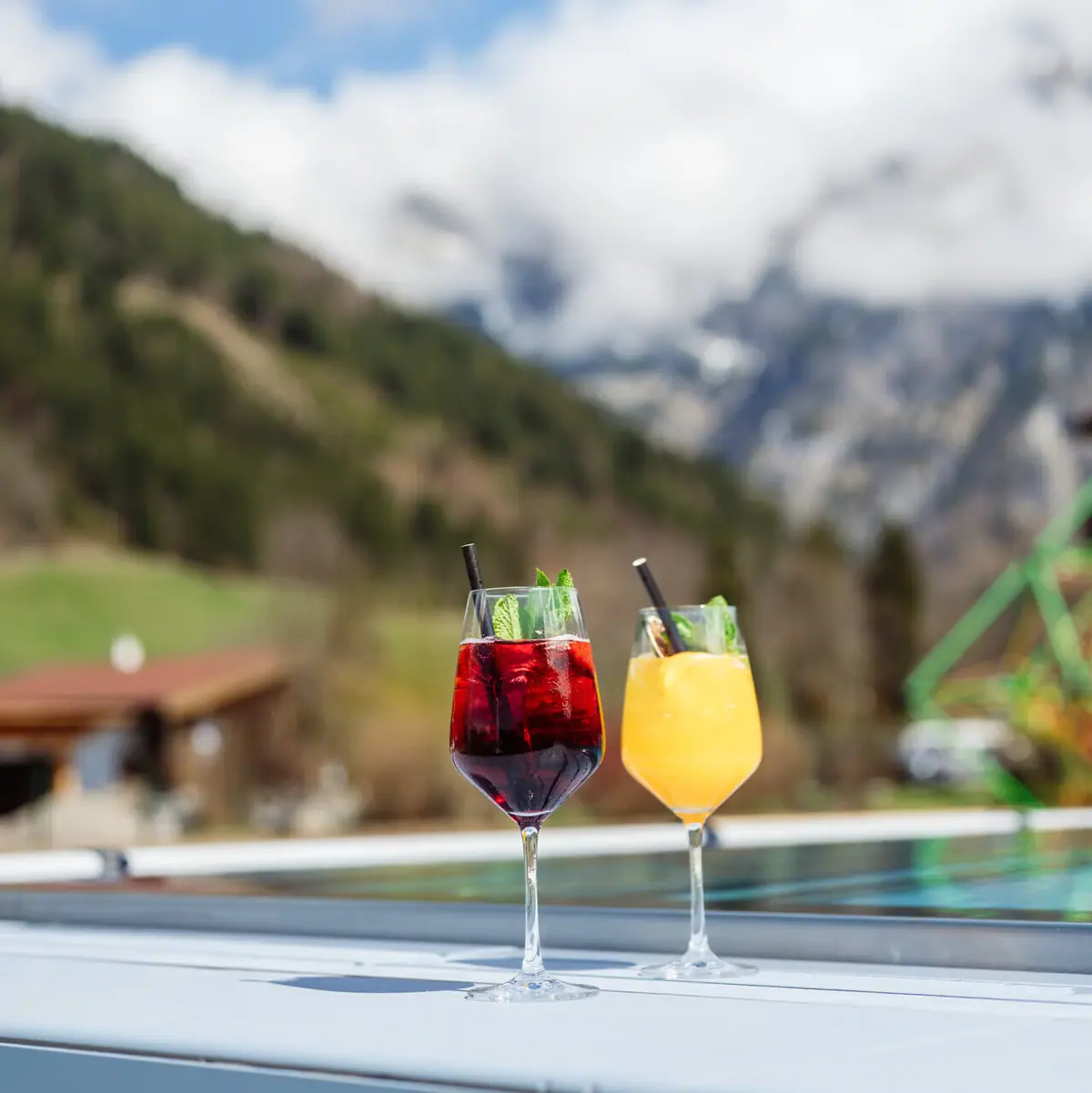 Zwei Gläser mit Getränken auf einem Tisch im Freien.